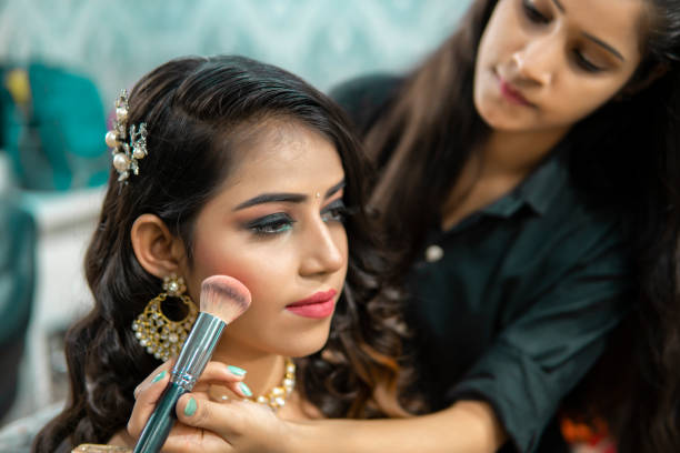 Bride getting her hair elegantly styled by a beautician at Bright Luxe Salon &amp; Studio, focused on intricate bridal hair design.