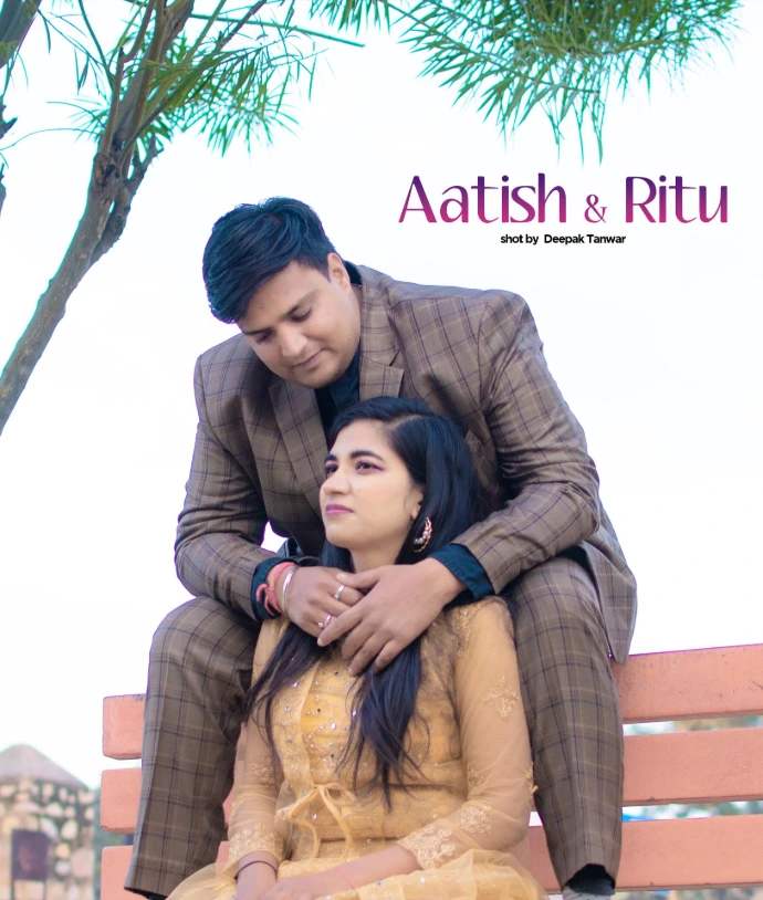 Groom and bride-to-be sitting together on a park bench during a bright luxe outdoor photoshoot.