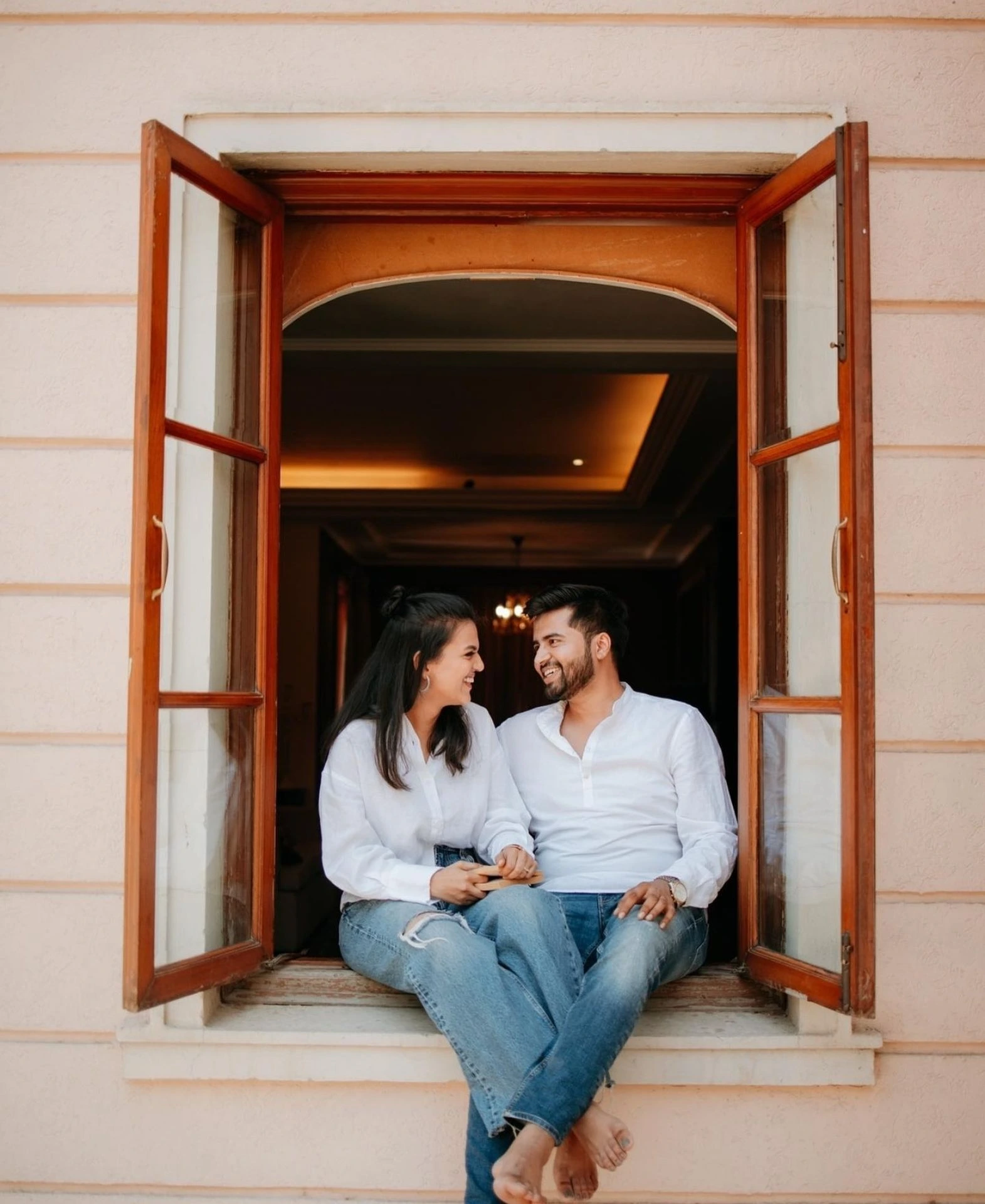Romantic pre-wedding couple sitting at window by Bright Luxe Salon &amp; Studio, Mahendergarh